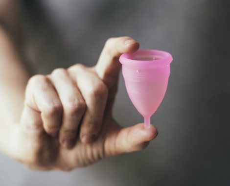 Young woman hand holding menstrual cup. Selective focus and shallow DOF